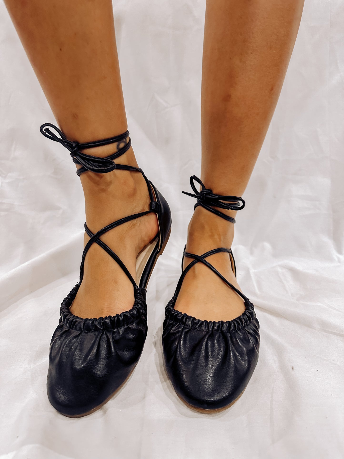 A pair of black lace up ballet flats