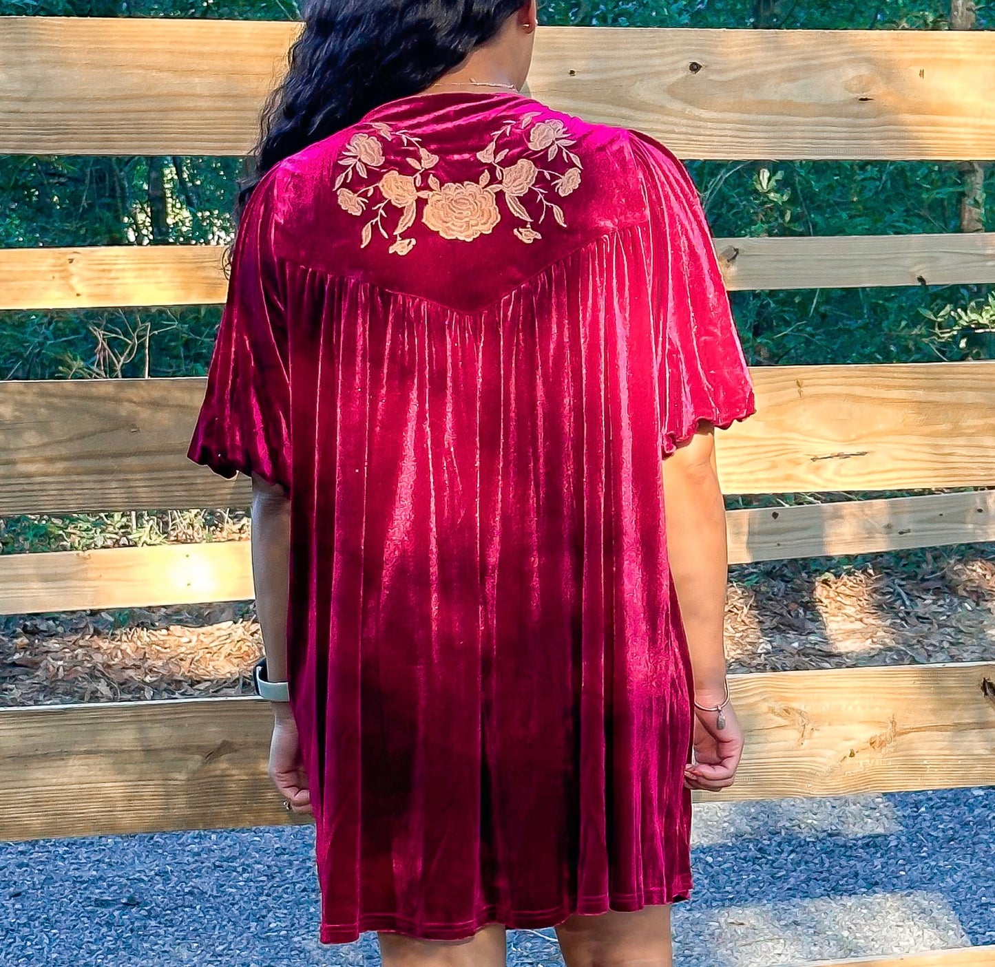 Maroon Dress with pleated detailing and scallop stitching details with floral embroidery on yoke and functional buttons with a tie tassel. Back paneling also has the floral embroidery detailing. The dress is short sleeve with flowy balloon sleeves.