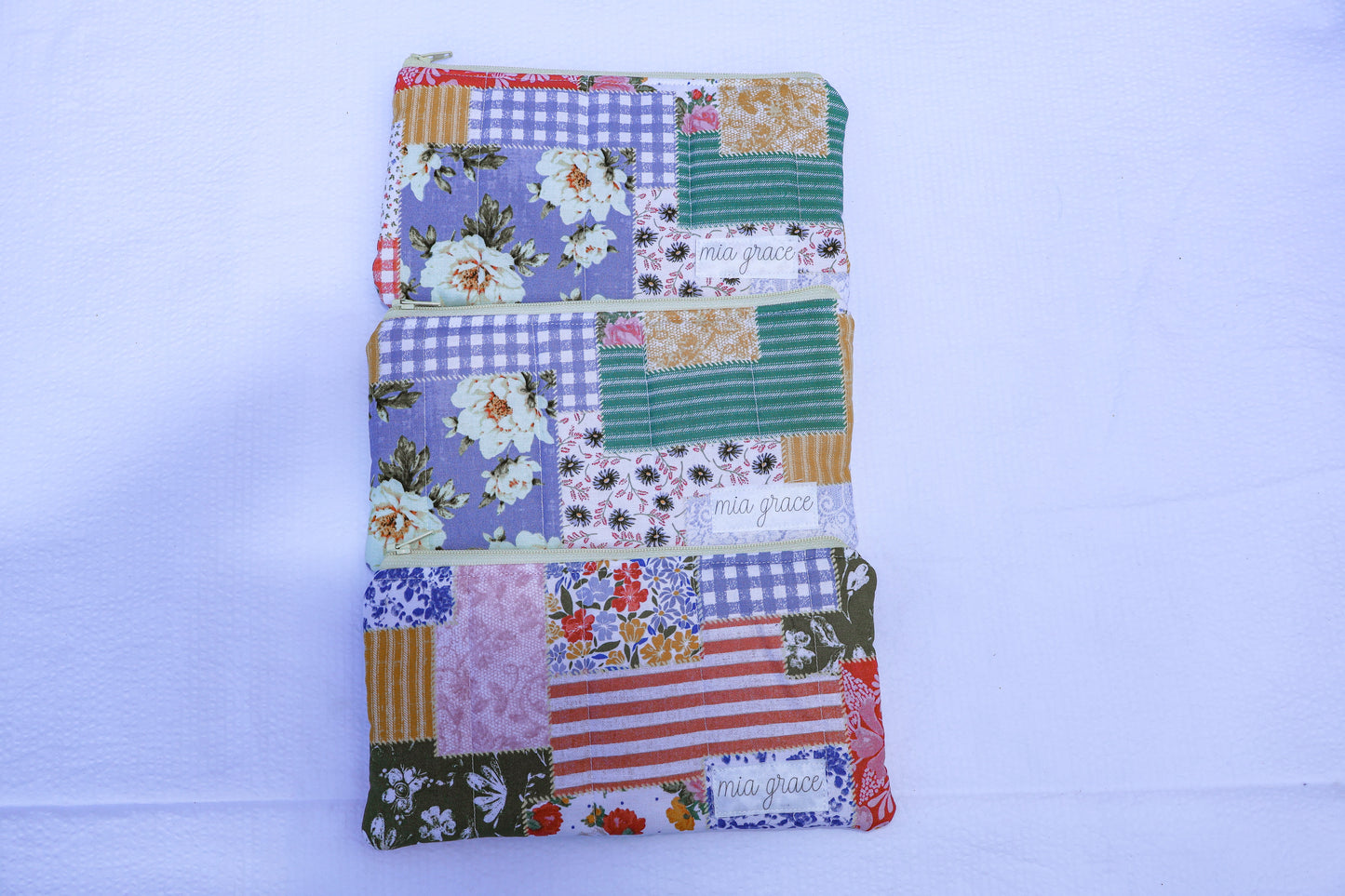 Patchwork fabric quilted pouch with a Mia grace branding label