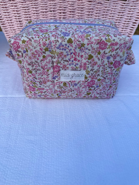 purple and pink floral-patterned quilted boxy pouch with a Mia Grace brand label and a purple zipper and pull tabs. Purple Inner Fabric