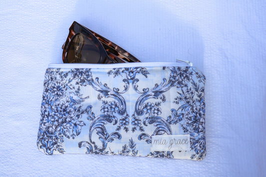 Blue floral patterned pouch with a zipper closure and a Mia grace brand label 