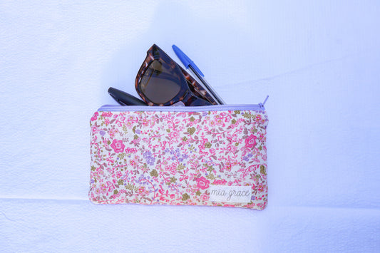Fabric pouch with pink and purple floral pattern and 'mia grace' branding label 