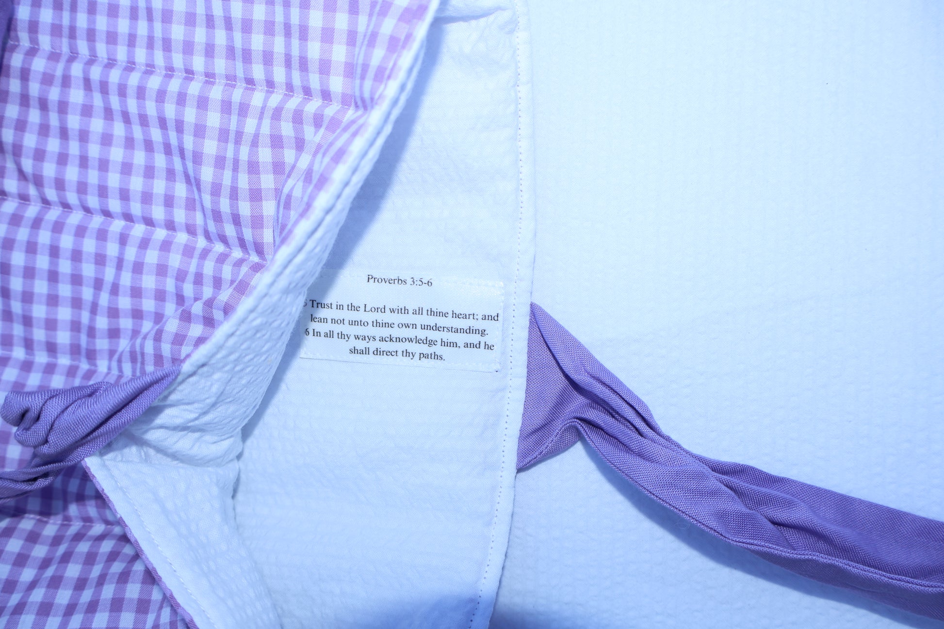 proverbs chapter 3 verse 5 and 6 on a label stitched into the inner  fabric of the bible sleeve. Inner fabric is white and the scripture text is black on a white label.