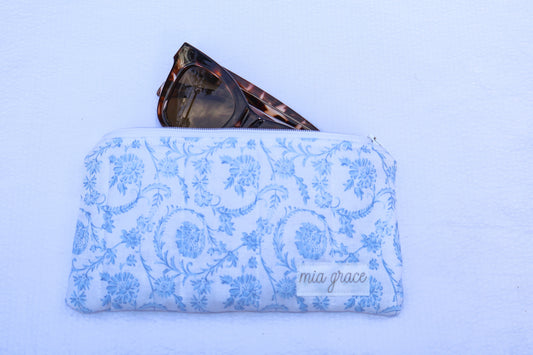 Fabric pouch with blue floral pattern and 'mia grace' branding label 