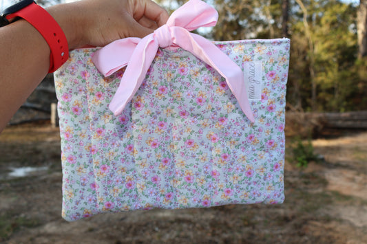 mint green, pink, and yellow floral fabric quilted bible or book sleeve with a soft pink bow tied closure. Mia grace brand label on the front 