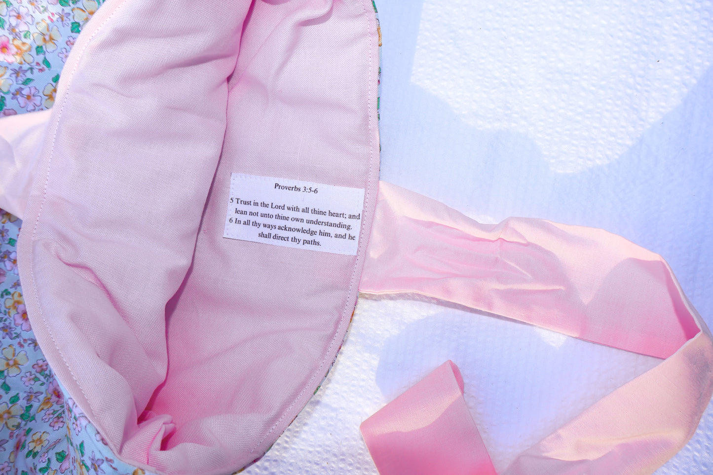 proverbs chapter 3 verse 5 and 6 on a label stitched into the inner  fabric of the bible sleeve. Inner fabric is soft pink and the scripture text is black on a white label.