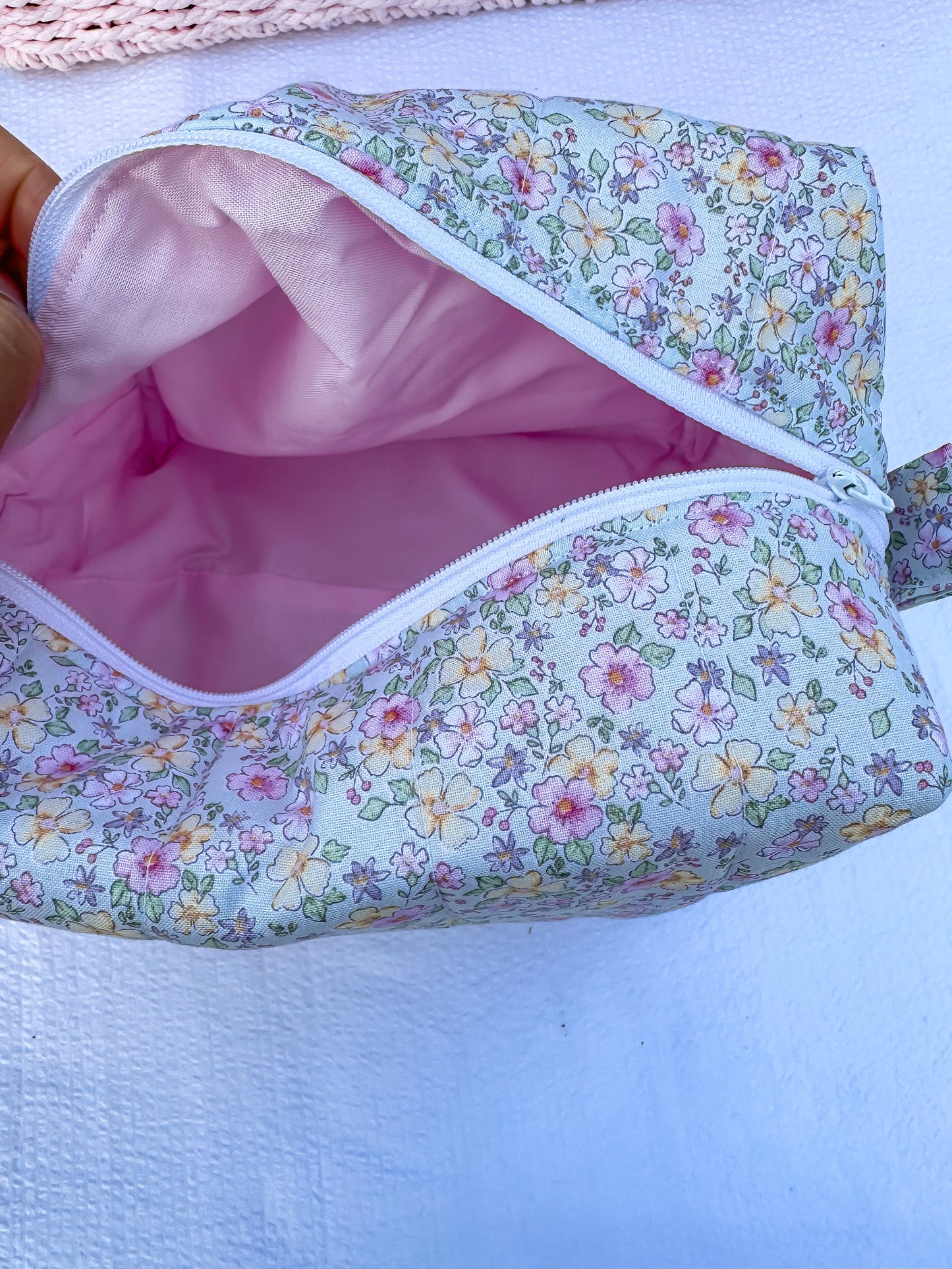 mint color,pink, and yellow  floral-patterned quilted boxy pouch with a Mia Grace brand label and a white zipper and pull tabs. Pink Inner Fabric
