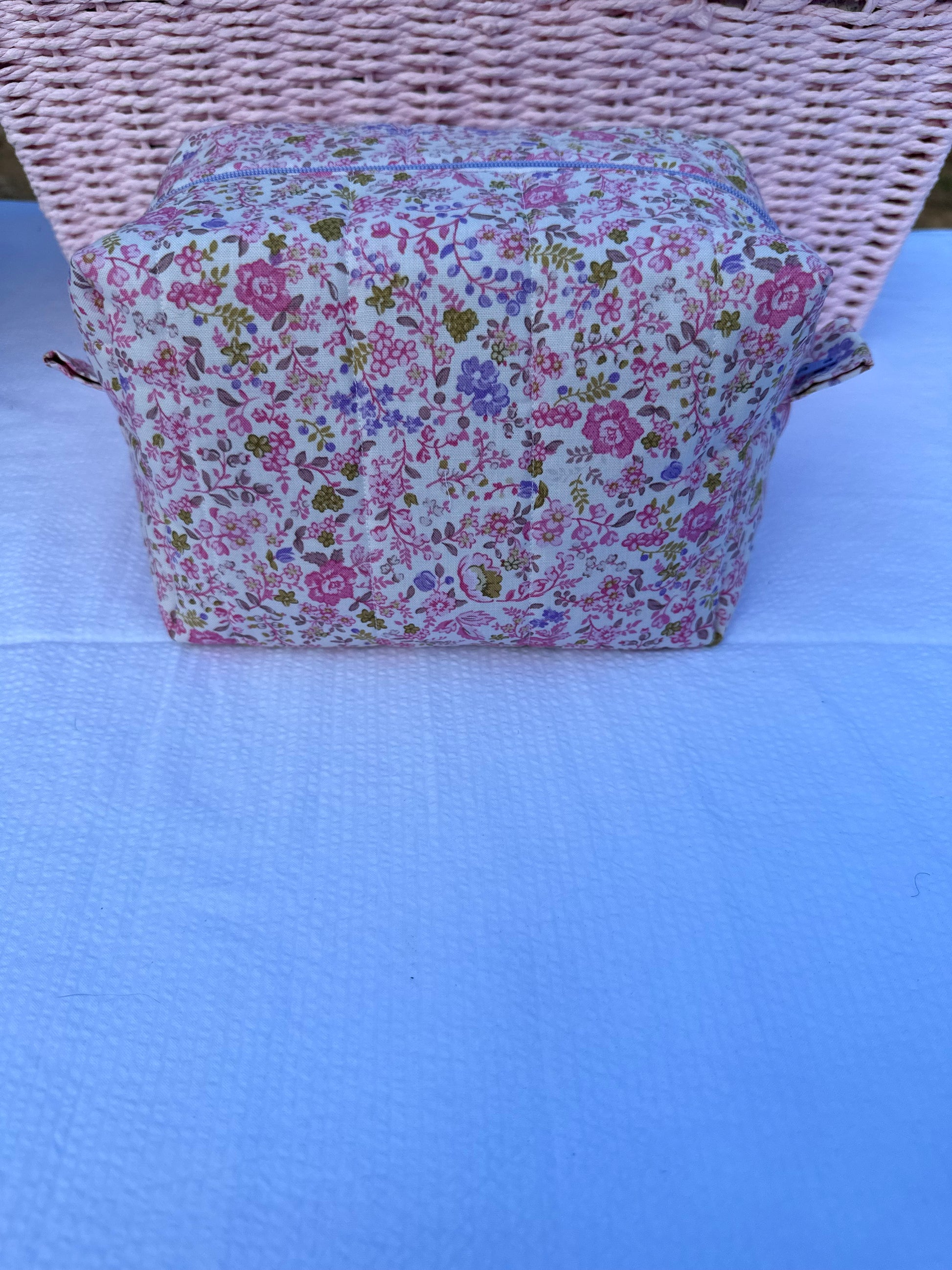 purple and pink floral-patterned quilted boxy pouch with a Mia Grace brand label and a purple zipper and pull tabs. Purple Inner Fabric