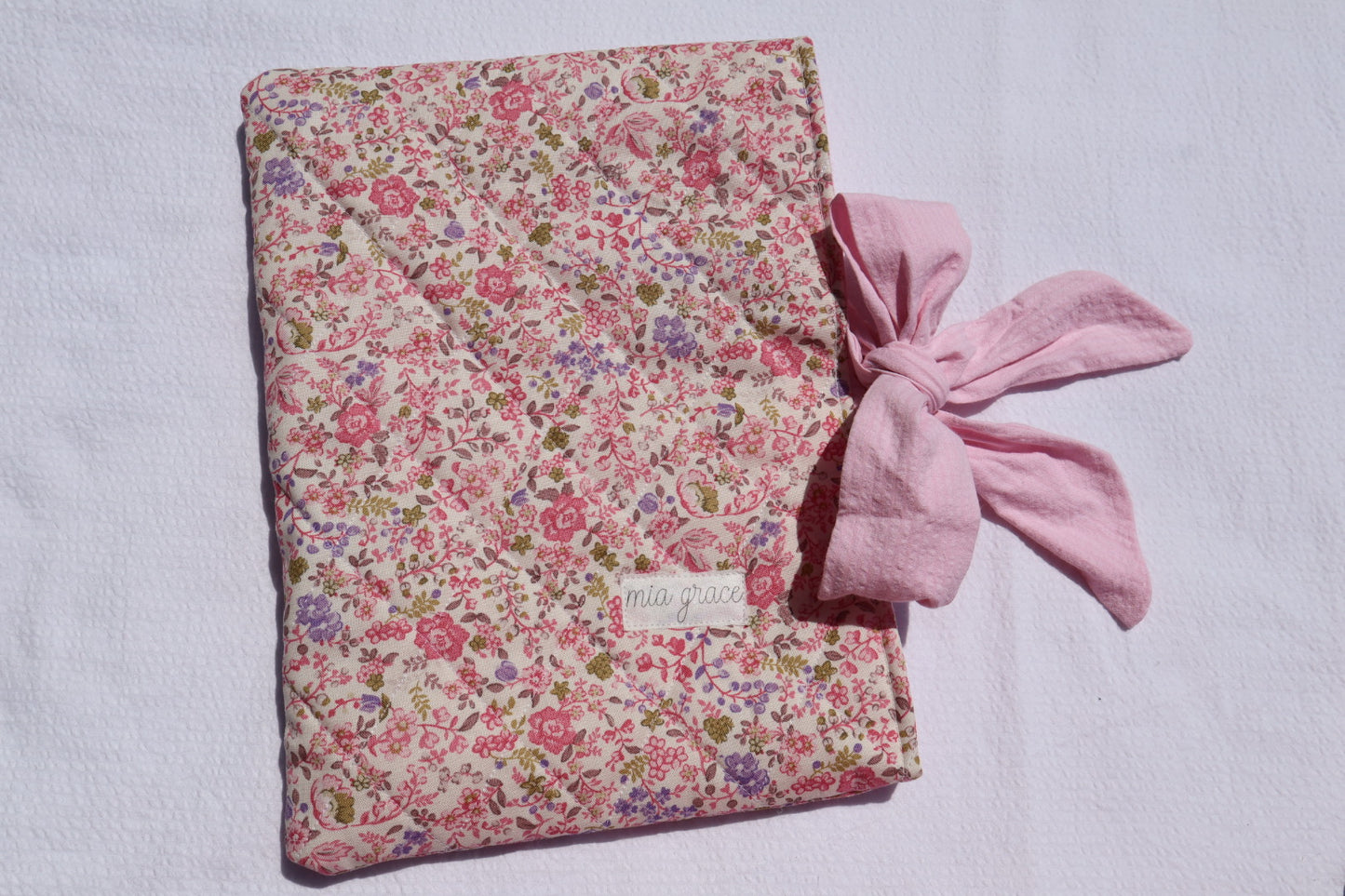 pink and purple  Floral-patterned fabric with a pink bow tie closure and a Mia grace brand label