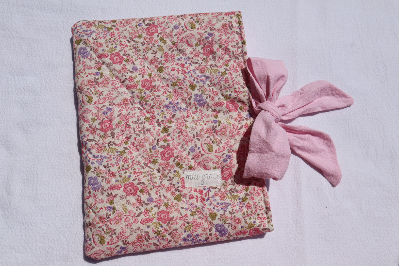 pink and purple  Floral-patterned fabric with a pink bow tie closure and a Mia grace brand label
