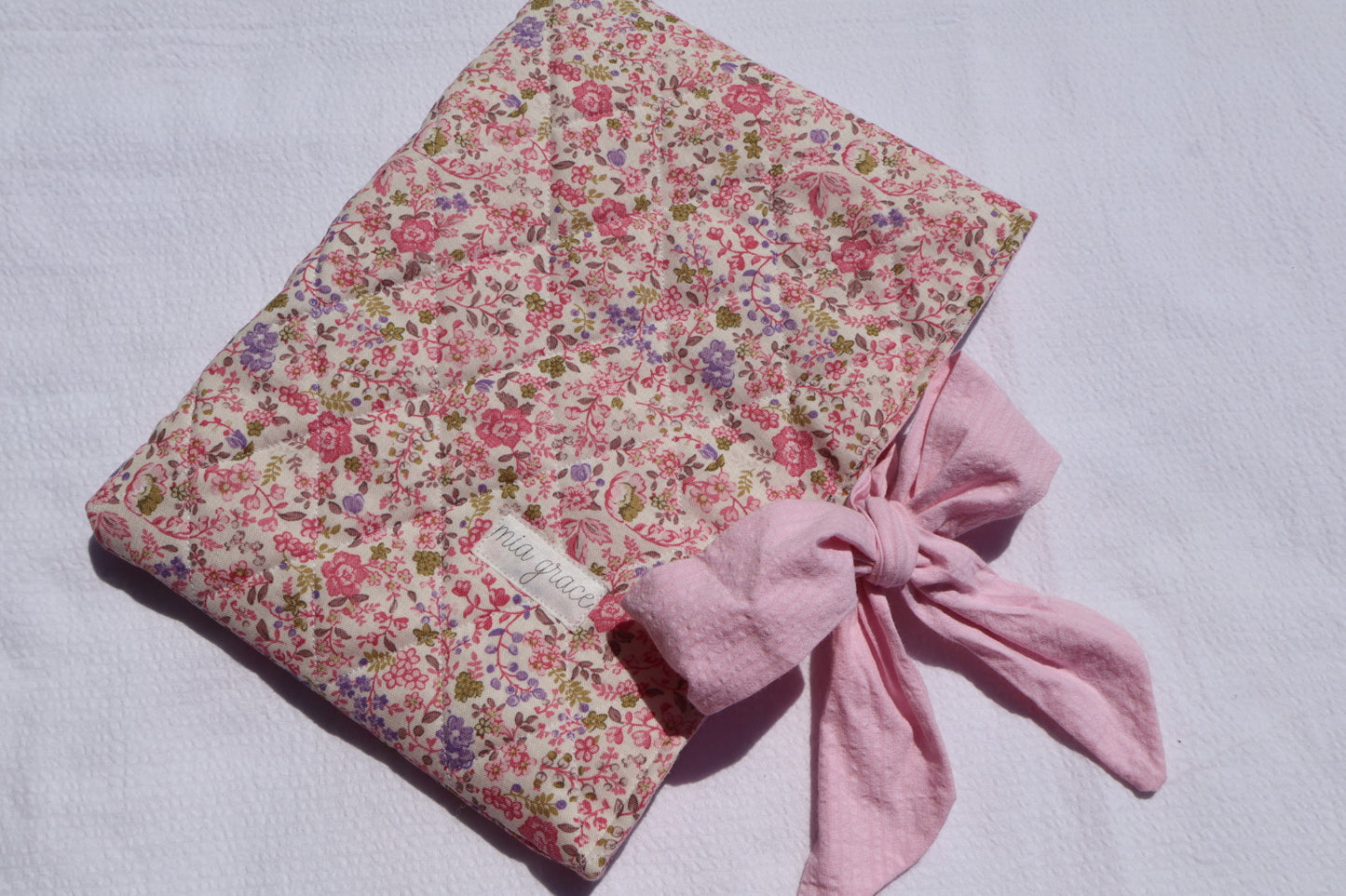 pink and purple  Floral-patterned fabric with a pink bow tie closure and a Mia grace brand label