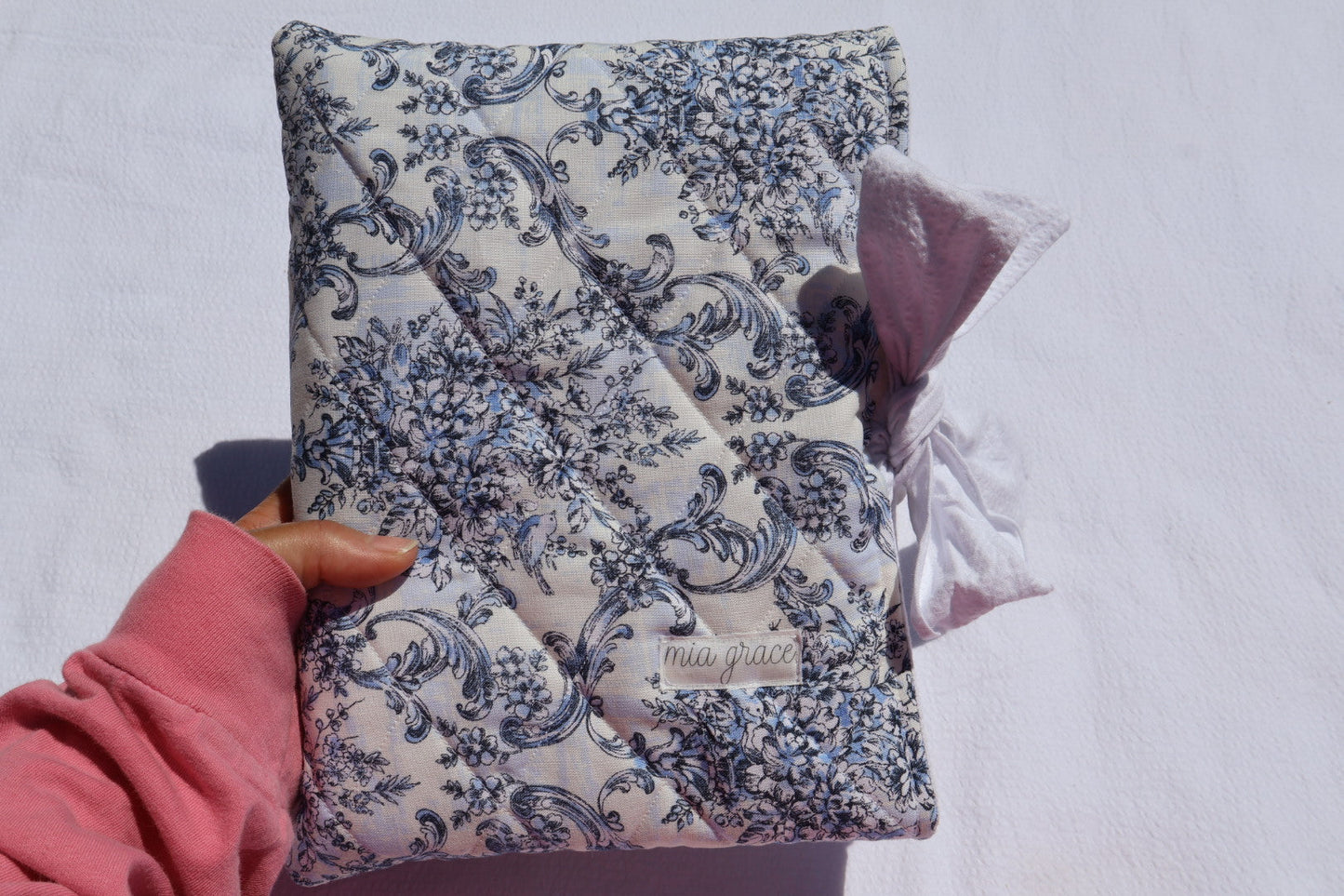 blue Floral-patterned fabric with a white bow tie closure and a Mia grace brand label