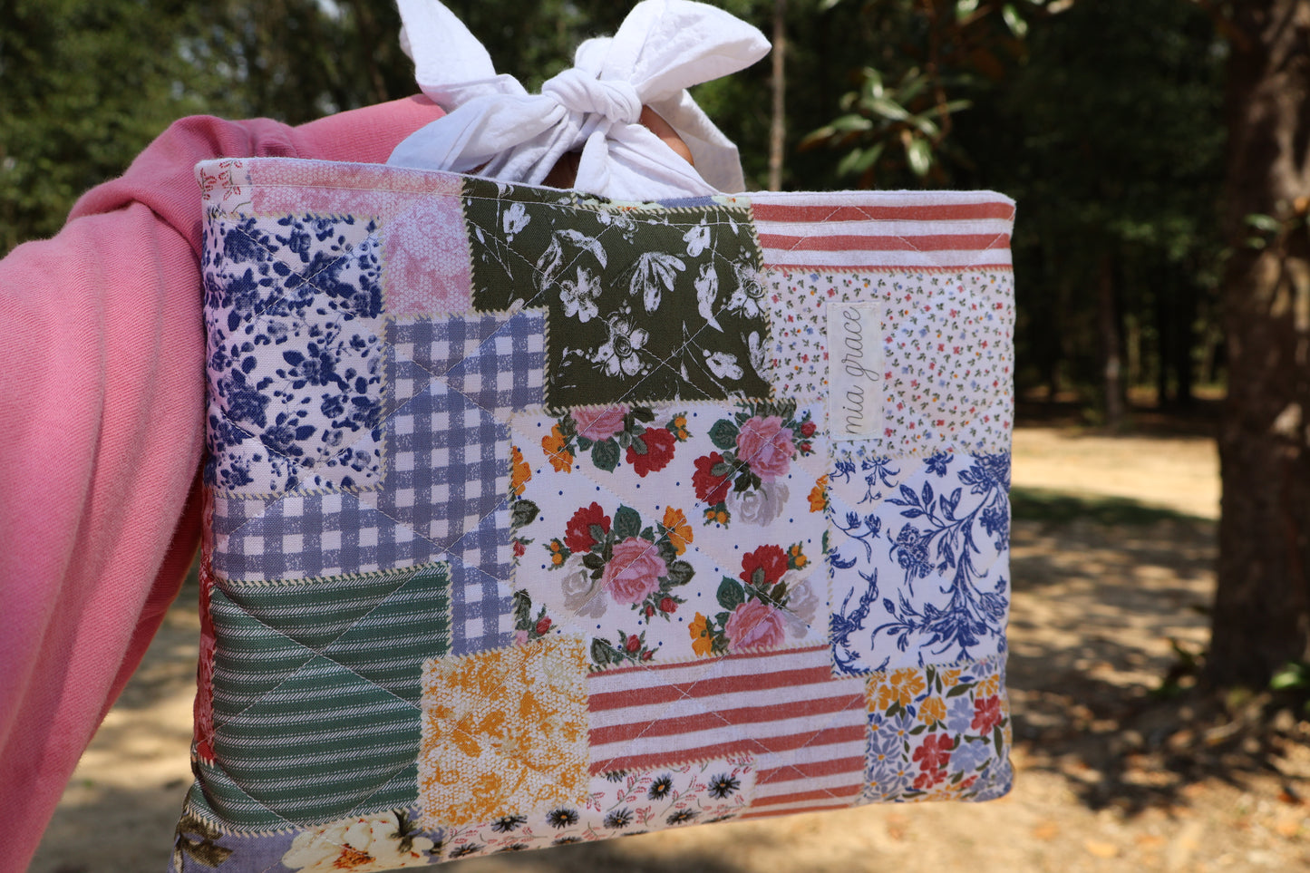 patchwork fabric quilted bible or book sleeve with Mia grace brand label and a white bow tied closure