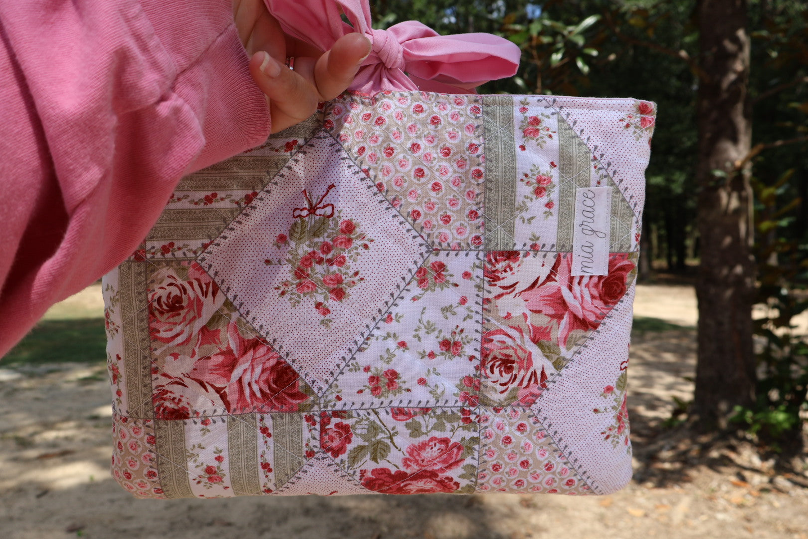 Patchwork Floral pink and green fabric  and a pink ribbon  bow tie closure and a Mia grace branding label