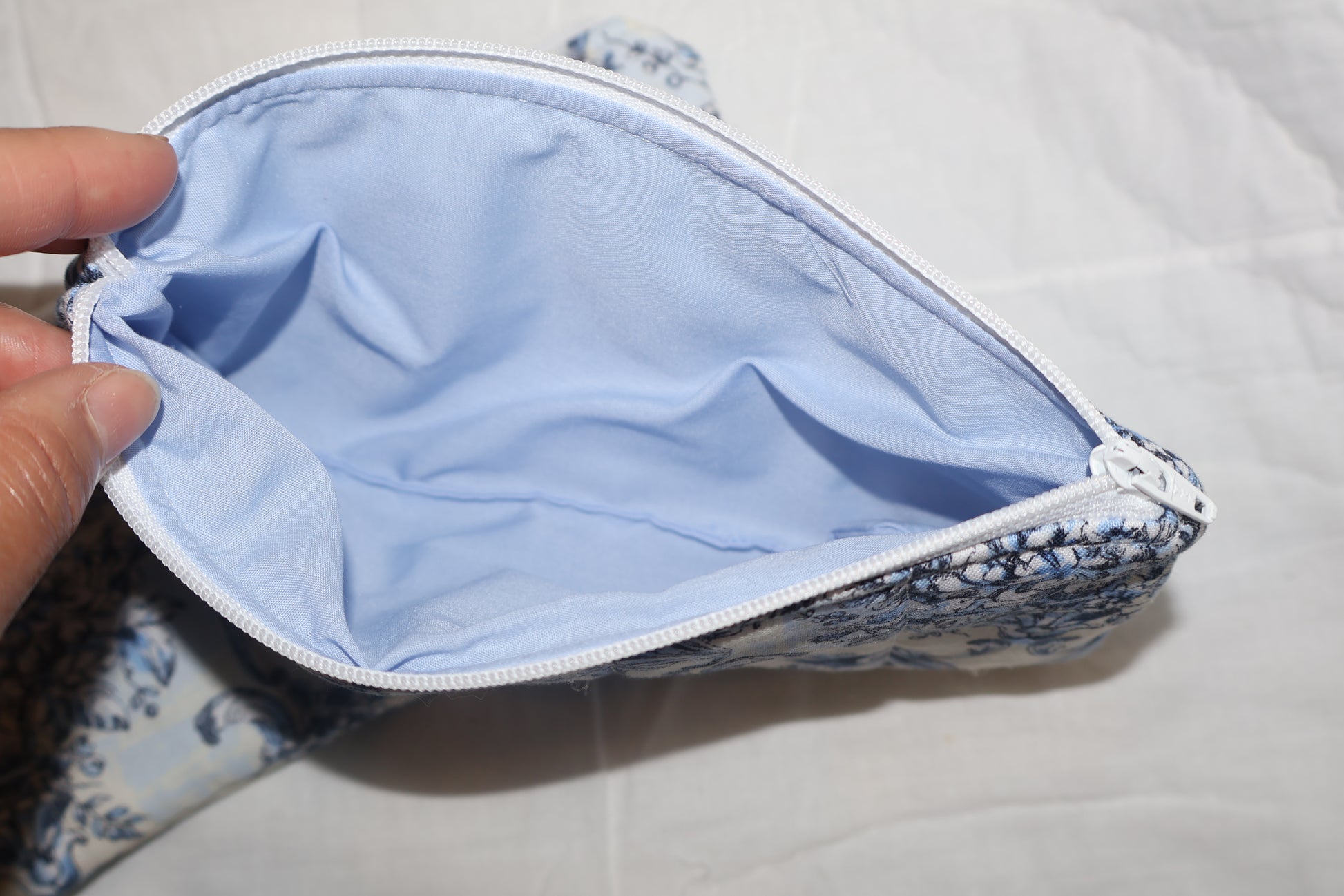 close up of a blue inner fabric and a white zipper 