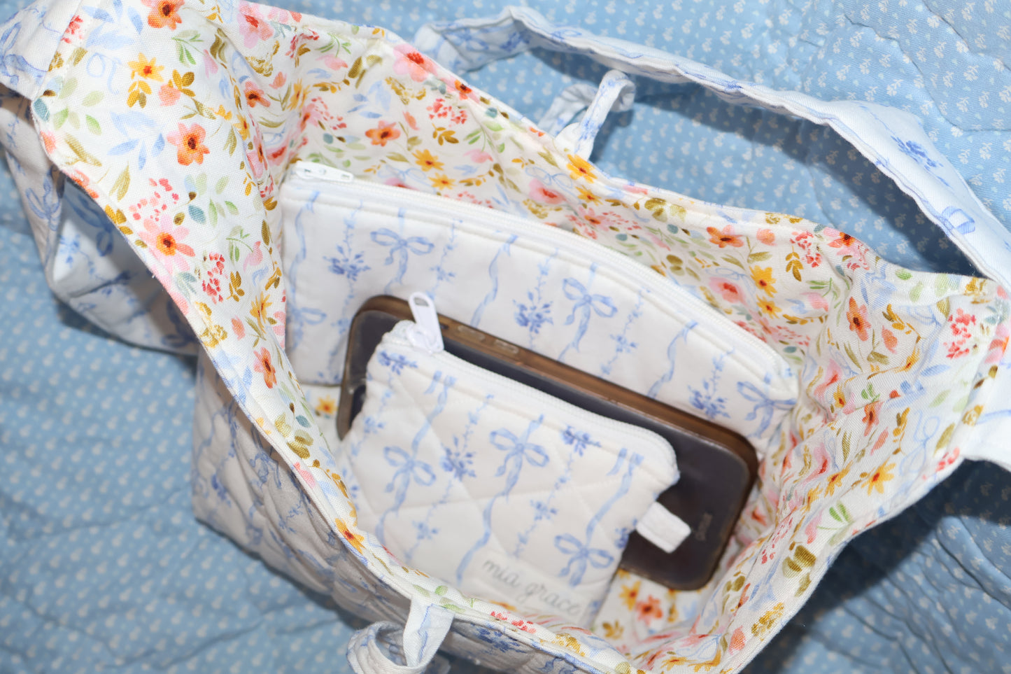 shoulder tote with a pencil case, keychain wallet, and a cellphone inside. 