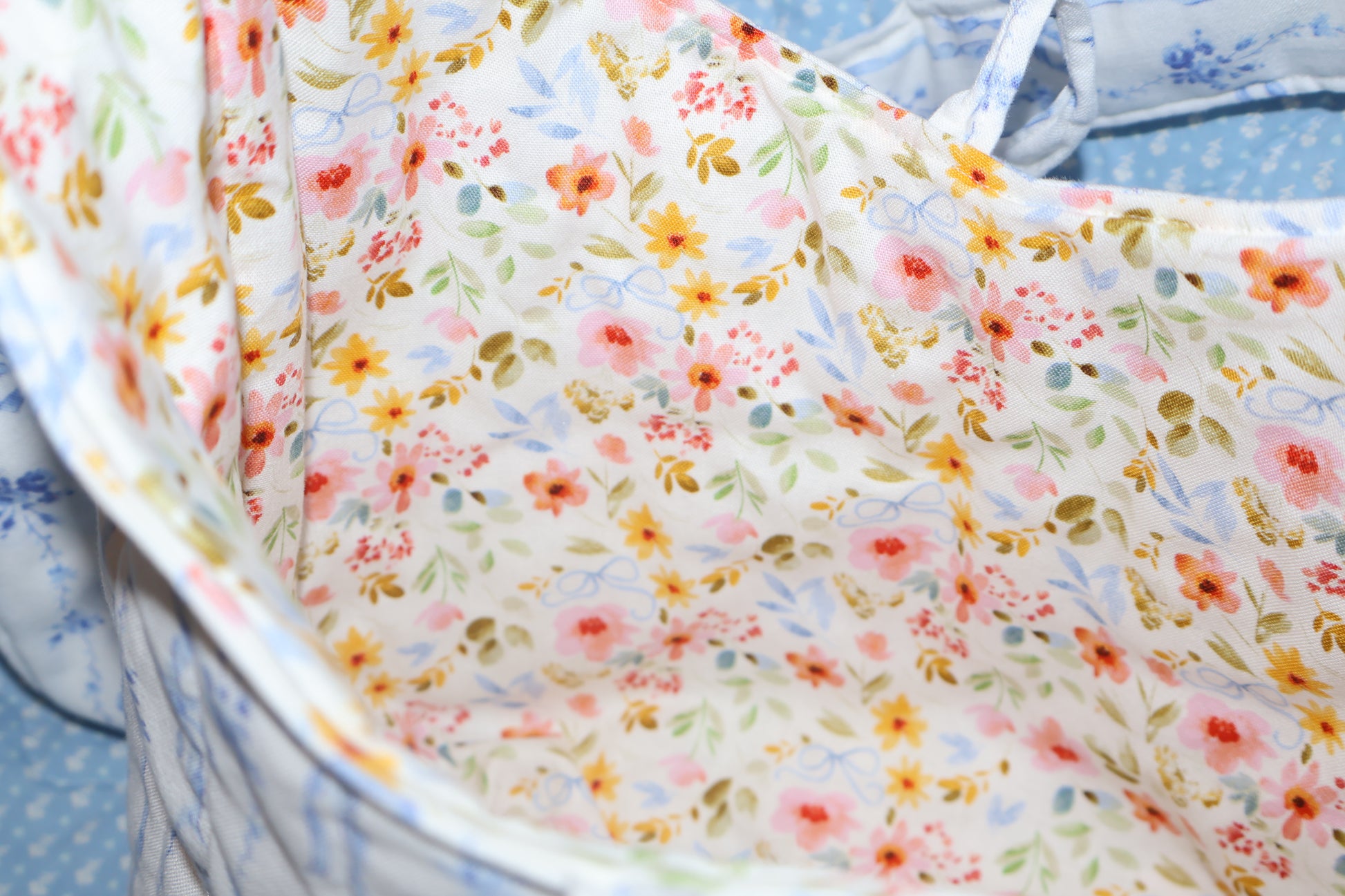shoulder bag inner fabric closeup photo featuring a floral fabric with bows on a cream background. 